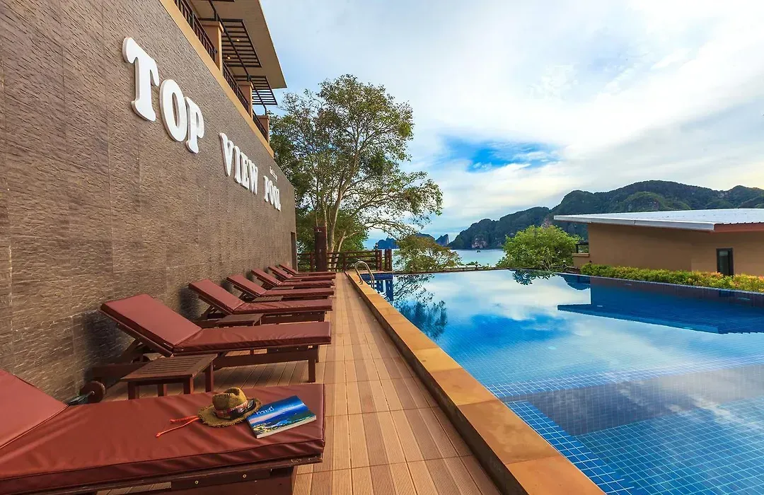 Outdoor pool with the TOP VIEW wall sign, loungers and panoramic bay views