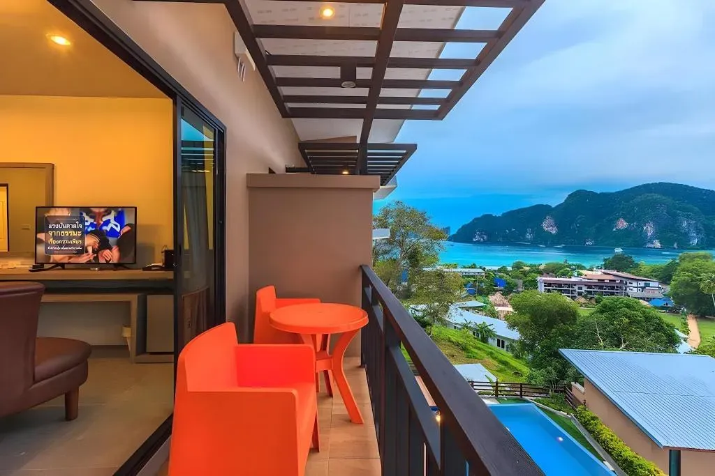 Private guest balcony with seating and views over the pool and the sea